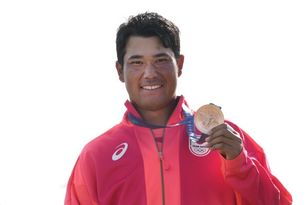 Hideki Matsuyama, of Japan, pose with his bronze medal following the medal ceremony for the men's golf at the 2024 Summer Olympics, Sunday, Aug. 4, 2024, at Le Golf National in Saint-Quentin-en-Yvelines, France. Scottie Scheffler, of the United States, won the gold medal with Tommy Fleetwood, of Britain, silver. (AP Photo/Matt York)