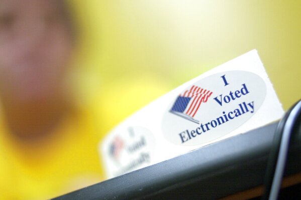 A volunteer shows a sticker that was being handed out at at the Washoe County administration complex in Reno, Nev., Tuesday, Sept. 7, 2004. Alarmed by software glitches, security breaches and computer crashes at voting precincts, legislators and election officials from Washington, D.C. to California are considering an alternative from an unlikely place: Nevada.  (AP Photo/Reno Gazette-Journal, Candice Towell) 