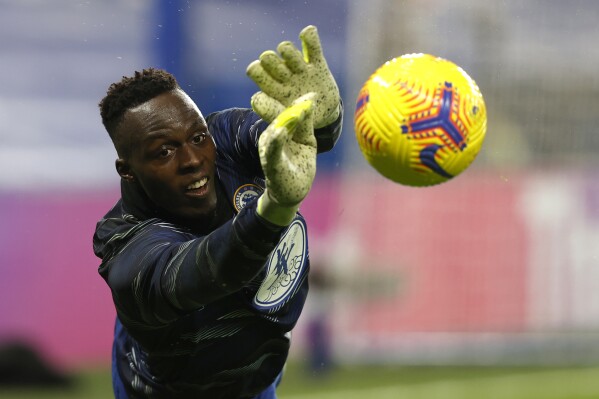 FILE - Chelsea goalkeeper Edouard Mendy warming up before the English Premier League soccer match between Chelsea and Newcastle United at Stamford Bridge Stadium in London, England, Monday, Feb. 15, 2021. Goalkeeper Edouard Mendy has joined Saudi Arabian team Al-Ahli. He becomes the latest Chelsea player to head to the oil-rich kingdom. (Adrian Dennis/Pool via AP, File)