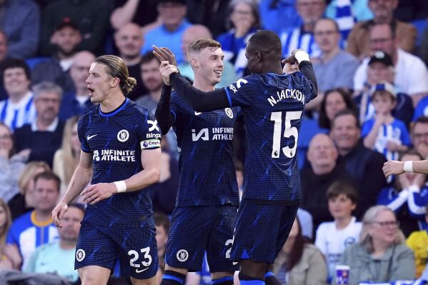 Chelsea's Cole Palmer, center, celebrates after scoring the opening goal during the English Premier League soccer match between Brighton and Hove Albion and FC Chelsea in Brighton and Hove, England, Wednesday, May 15, 2024. (Adam Davy/PA via AP)