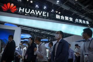 FILE - Visitors walk past a booth for Chinese technology firm Huawei at the PT Expo in Beijing on Sept. 28, 2021. China’s government accused Washington on Tuesday, Jan. 31, 2023, of pursuing “technology hegemony” following news reports the United States might step up pressure on tech giant Huawei by blocking all access to American suppliers. (AP Photo/Mark Schiefelbein, File)