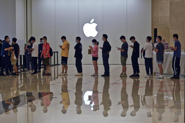 People line up at an Apple Store to buy the latest iPhone 13 handsets in Nanning in south China's Guangxi Zhuang Autonomous Region on Sept. 24, 2021. Global shoppers face possible shortages of smartphones and other goods ahead of Christmas after power cuts to meet government energy use targets forced Chinese factories to shut down and left some households in the dark. (Chinatopix Via AP)