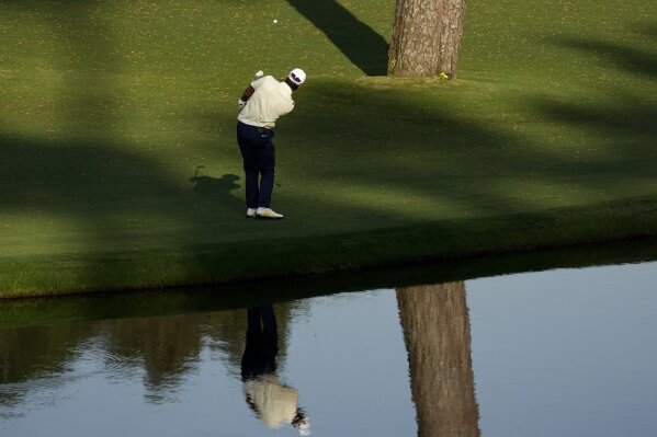 Hideki Matsuyama, of Japan, chips to the green on the 15th hole after putting his approach shot into the water during the final round of the Masters golf tournament on Sunday, April 11, 2021, in Augusta, Ga. (AP Photo/Charlie Riedel)