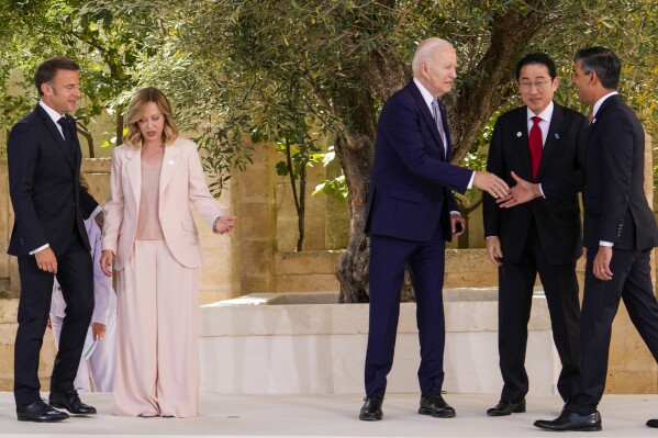 U.S. President Joe Biden, center, shakes hands with Britain's Prime Minister Rishi Sunak, right, next to Japan's Prime Minister Fumio Kishida, second right, French President Emmanuel Macron, left, and Italian Prime Minister Giorgia Meloni as they prepare for a group photo during a G7 world leaders summit at Borgo Egnazia, Italy, Thursday, June 13, 2024. (AP Photo/Luca Bruno)