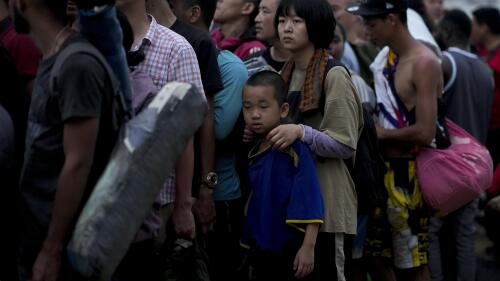 Chinese migrants line up to take a boat to Lajas Blancas after walking across the Darien Gap in Bajo Chiquito, Panama, Sunday, May 7, 2023. (AP Photo/Natacha Pisarenko)