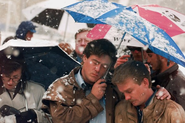 FILE - Brian Harrington, right, and Chuck Beauchine pray with other mourners during the funeral of Matthew Shepard at St. Mark's Episcopal Church Friday, Oct. 16, 1998, in Casper, Wyo. Shepard, an openly gay University of Wyoming student, died Monday from a beating in Laramie, Wyoming that's widely considered to have been at least in part motivated by his sexual orientation. (AP Photo/Michael S. Green, File)