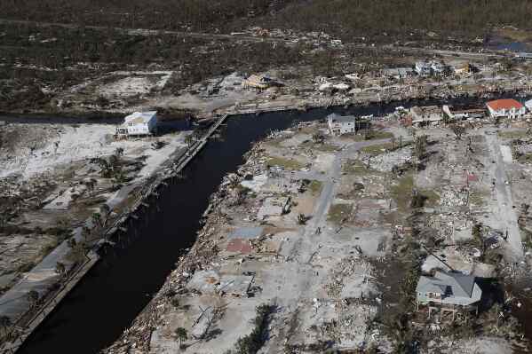 Devastation from Hurricane Michael is visible including the area around Bonny Paulson's home, center top, in Mexico Beach, Fla., Friday, Oct. 12, 2018. Some developers are building homes like Paulson's with an eye toward making them more resilient to the extreme weather that's increasing with climate change, and friendlier to the environment at the same time. (AP Photo/Gerald Herbert)