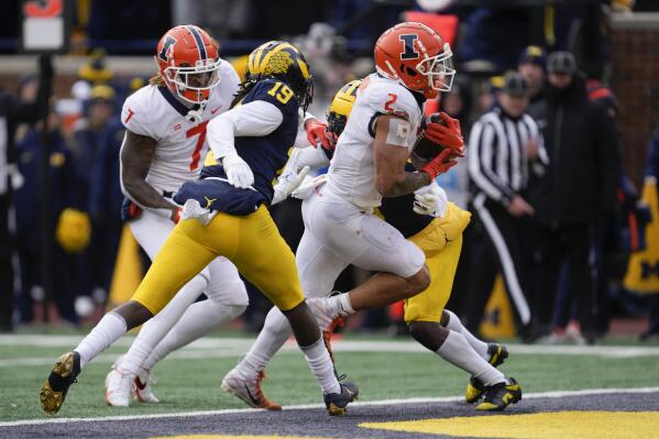 Illinois running back Chase Brown (2) scores on a eight-yard touchdown run against Michigan in the second half of an NCAA college football game in Ann Arbor, Mich., Saturday, Nov. 19, 2022. (AP Photo/Paul Sancya)