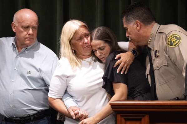 FILE - Los Angeles County Sheriff Robert Luna, right, comforts sheriff's deputy Ryan Clinkunbroomer's fiancee Brittany Lindsey, second from right, joined by Clinkunbroomer's parents, Kim and Mike Clinkunbroomer, during a news conference at the Hall of Justice in downtown Los Angeles on Wednesday, Sept. 20, 2023. The man charged with murder in the ambush killing of Ryan Clinkunbroomerentered a plea of not guilty by reason of insanity on Wednesday, Sept. 27.(AP Photo/Richard Vogel, File)