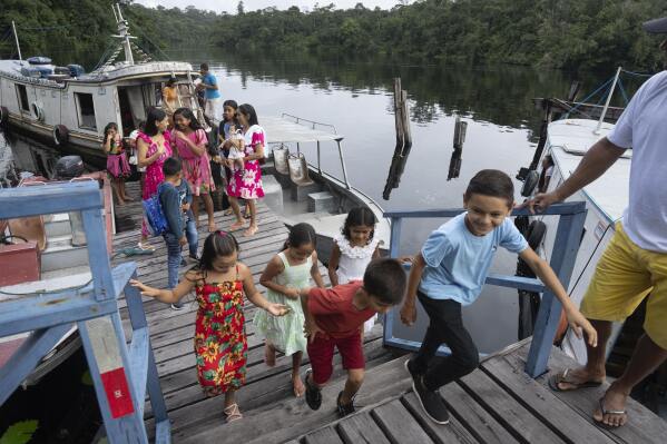 Children arrive at the Emilio Goeldi Museum's scientific station in the Caxiuana National Forest in Para state, Brazil, Friday, March 21, 2025. (AP Photo/Jorge Saenz)