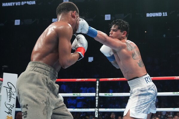 Ryan Garcia, right, punches Devin Haney during the 11th round of a super lightweight boxing match early Sunday, April 21, 2024, in New York. Garcia won the fight. (AP Photo/Frank Franklin II)