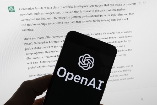 FILE - The OpenAI logo is seen on a mobile phone in front of a computer screen displaying output from ChatGPT, March 21, 2023, in Boston. OpenAI has introduced a new artificial intelligence model. It says it works faster than previous versions and can reason across text, audio and video in real time. (AP Photo/Michael Dwyer, File)