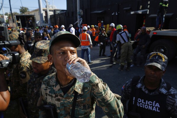 A soldier hydrates while rescue workers search for survivors at the Jet Set nightclub after its roof collapsed during a merengue concert in Santo Domingo, Dominican Republic, Tuesday, April 8, 2025. (AP Photo/Eddy Vittini)