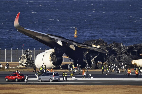 Burnt Japan Airlines plane is seen at Haneda airport on Thursday, Jan. 4, 2024, in Tokyo, Japan. A transcript of communication between traffic control and two aircraft that collided and burst into flames at Tokyo’s Haneda Airport showed that only the larger Japan Airlines passenger flight was given permission to use the runway where a coast guard plane was preparing for takeoff. (Kyodo News via AP)