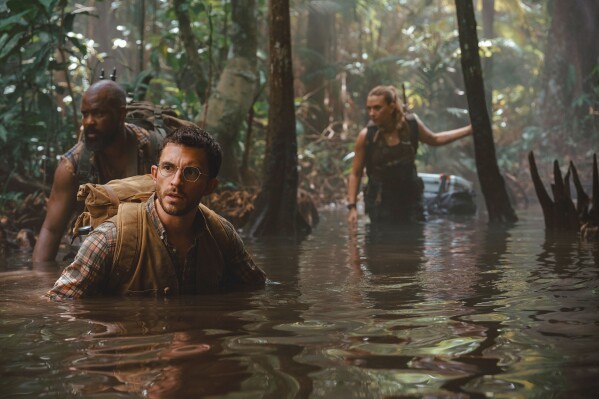 This image released by Universal Pictures and Amblin Entertainment shows, from left, Bechir Sylvain, Jonathan Bailey, and Scarlett Johansson in a scene from " Jurassic World Rebirth." (Jasin Boland/Universal Pictures and Amblin Entertainment via AP)
