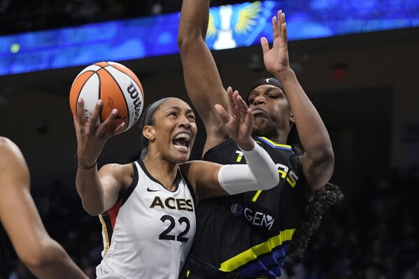 Las Vegas Aces forward A'ja Wilson (22) makes a move to the basket as Dallas Wings center Teaira McCowan defends during the first half of Game 3 of a WNBA basketball playoffs semifinal Friday, Sept. 29, 2023, in Arlington, Texas. (AP Photo/Sam Hodde)