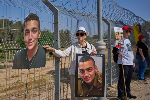 Varda Ben Baruch holds a picture of her grandson Edan Alexander, who is held hostage in Gaza, gathers with other families to call out on loudspeakers in hopes that their loved ones will hear them, near the Gaza border in Kibbutz Nir Oz, southern Israel, April 20, 2025. (AP Photo/Ohad Zwigenberg, File)