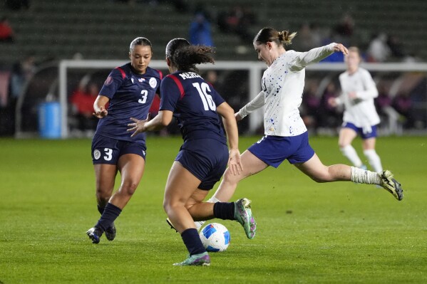 United States' Olivia Moultrie (13) shoots the ball against Dominican Republic's Stella Tapia (3) and Renata Mercerdes (16) during the first half of the CONCACAF Women鈥檚 Gold Cup soccer tournament at Dignity Health Sports Park in Carson, Calif., Tuesday, Feb. 20, 2024. (APPhoto/Damian Dovarganes)