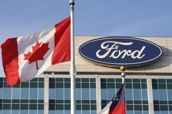 Una bandera canadiense ondea frente al logotipo de Ford en la sede de la compañía en Dearborn, Michigan, el 26 de octubre de 2009. (AP Foto/Carlos Osorio)