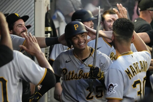Pittsburgh Pirates' Endy Rodriguez is congratulated by teammates in the dugout after hitting a solo home run during the sixth inning of a baseball game against the Los Angeles Angels Saturday, July 22, 2023, in Anaheim, Calif. (AP Photo/Mark J. Terrill)