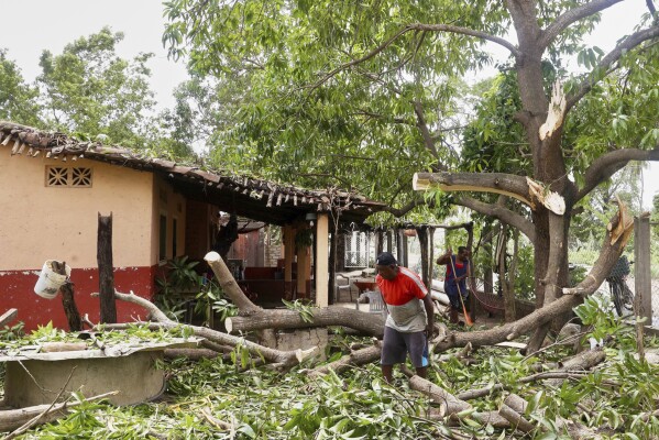Residentes retiran los escombros que dejó a su paso el huracán Erick, cerca de Charco Redondo, en el estado de Oaxaca, México, el 19 de junio de 2025. (AP Foto/Luis Alberto Cruz)