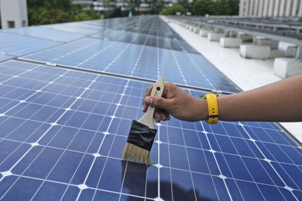 FILE - A workers cleans solar panels that provide partial electrical power to Istiqlal Mosque in Jakarta, Indonesia, Wednesday, March 29, 2023. The urgency for Southeast Asian nations to switch to clean energy to combat climate change is reinvigorating a 20-year-old plan for the region to share power. (AP Photo/Tatan Syuflana, File)