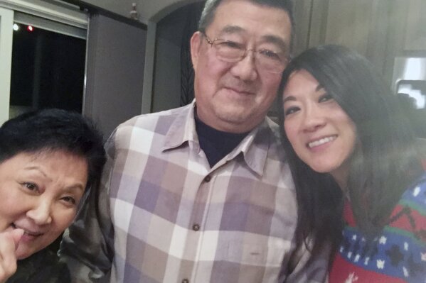 This December 2016 photo provided by the family shows, from left, Lu Wang, Ming Wang and Anne Peterson. Ming Wang, 71, was sickened in March 2020 on a cruise from Australia with his wife, a break after decades of running the family’s Chinese restaurant in Papillion, Neb. In the 74 days he was hospitalized, doctors desperately tried various experimental approaches, including enrolling him in a study of an antiviral drug that ultimately showed promise. Ming died on June 8. “It was just touch and go. Everything they wanted to try we said yes, do it,” said his daughter, Anne Peterson. “We would give anything to have him back, but if what we and he went through would help future patients, that’s what we want.” (Anne Peterson via AP)