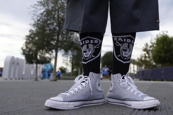 A Las Vegas Raiders poses in front of SoFi stadium before an NFL football game against the Los Angeles Chargers, Monday, Oct. 4, 2021, in Inglewood, Calif. (AP Photo/Marcio Jose Sanchez)