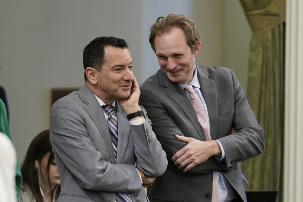 FILE -Former California Assembly Speaker Anthony Rendon, left, and Assembly Republican Leader James Gallagher talk during the Assembly session at the Capitol in Sacramento, Calif., Wednesday, Aug. 31, 2022. Rendon created the Select Committee on Happiness and Public Policy Outcomes to study how state policy can make Californians happier. (AP Photo/Rich Pedroncelli,File)