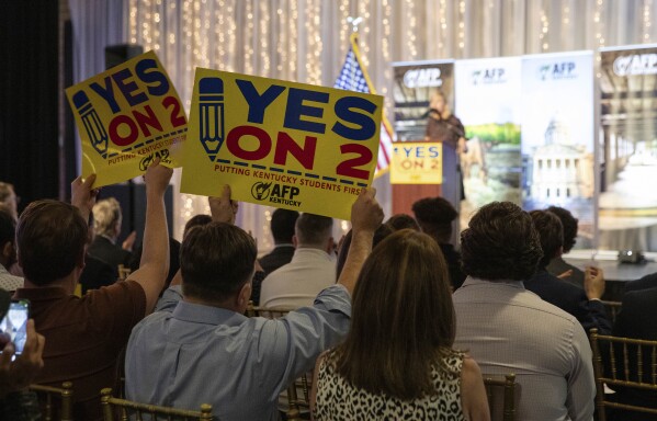 Supporters of Kentucky's Amendment 2 wave signs and foam fingers at the Americans for Prosperity—Kentucky rally for Amendment 2 in downtown Bowling Green, Ky., Monday, Oct. 28, 2024. (Grace Ramey McDowell/Daily News via AP)