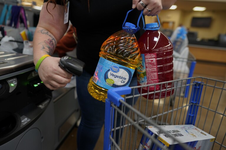 Jesse Johnson of the Family Resource Center helps her client Jodi Ferdinandsen check out at Walmart in Findlay, Ohio, Thursday, Oct. 12, 2023. (AP Photo/Carolyn Kaster)