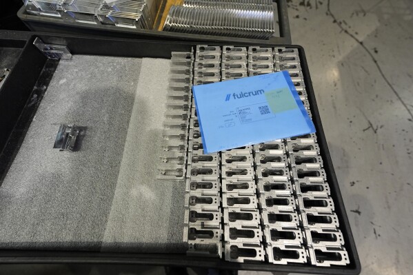 Semiconductor pieces sit in a shipping box as they are produced in a Mazak Variaxis machine at Reata Engineering and Machine Works Thursday, Feb. 15, 2024, in Englewood, Colo. Reata, which supplies the aviation and medical device industries, has invested heavily in software that automates its manufacturing processes. It's also been training workers to use more sophisticated equipment. (AP Photo/David Zalubowski)