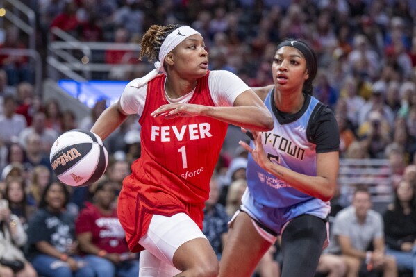 Indiana Fever forward NaLyssa Smith (1) looks to pass while being defended by Chicago Sky forward Angel Reese (5) during a WNBA basketball game Saturday, June 1, 2024, in Indianapolis. (AP Photo/Doug McSchooler)