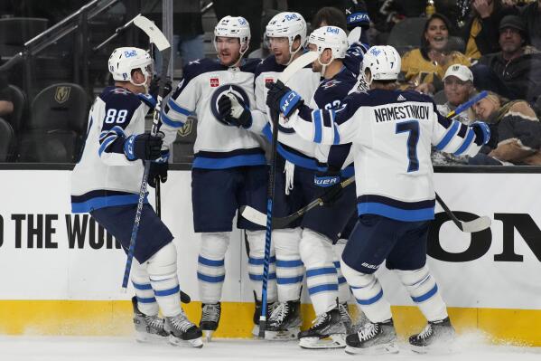 Winnipeg Jets celebrate after right wing Blake Wheeler, center, scored against the Vegas Golden Knights during the third period of Game 1 of an NHL hockey Stanley Cup first-round playoff series Tuesday, April 18, 2023, in Las Vegas. (AP Photo/John Locher)