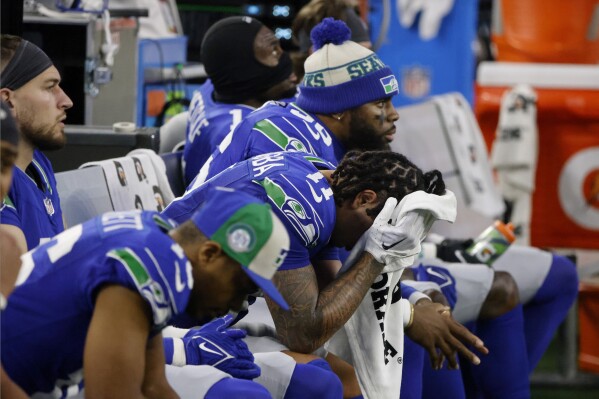 Seattle Seahawks' Jaxon Smith-Njigba (11) and teammates sit on the bench late in the second half of an NFL football game against the Dallas Cowboys in Arlington, Texas, Thursday, Nov. 30, 2023. (AP Photo/Michael Ainsworth)