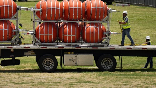 Dozens of large buoys that are set to be deployed in the Rio Grande are unloaded, Friday, July 7, 2023, in Eagle Pass, Texas, where border crossings continue to place stress on local resources. Advocates have raised concern that the barriers may have an adverse environmental impact. (AP Photo/Eric Gay)