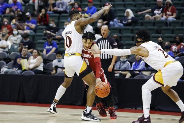 Alabama guard Jahvon Quinerly drives between Iona guards Berrick JeanLouis, left, and Elijah Joiner, right, during the first half of an NCAA college basketball game Thursday, Nov. 25, 2021, in Orlando, Fla. (AP Photo/Jacob M. Langston)