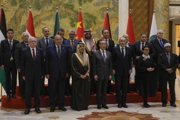 Chinese Foreign Minister Wang Yi, foreground center, stands with his counterparts from left, Palestine Foreign Minister Riyad al-Maliki, Egyptian Foreign Minister Sameh Shoukry, Saudi Arabia's Foreign Minister Faisal bin Farhan Al Saud, Jordanian Deputy Prime Minister and Foreign Minister Ayman Safadi, Indonesian Foreign Minister Retno Marsudi, Secretary-General of the Organization of Islamic Cooperation (OIC) Hissein Brahim Taha and their delegations as they pose for a group photo prior to their meeting at the Diaoyutai state guesthouse in Beijing, Monday, Nov. 20, 2023. China's foreign minister welcomed five Arab and Islamic counterparts to Beijing on Monday, saying his country would work with "our brothers and sisters" in the Arab and Islamic world to try to end the fighting in Gaza as soon as possible. (AP Photo/Andy Wong)