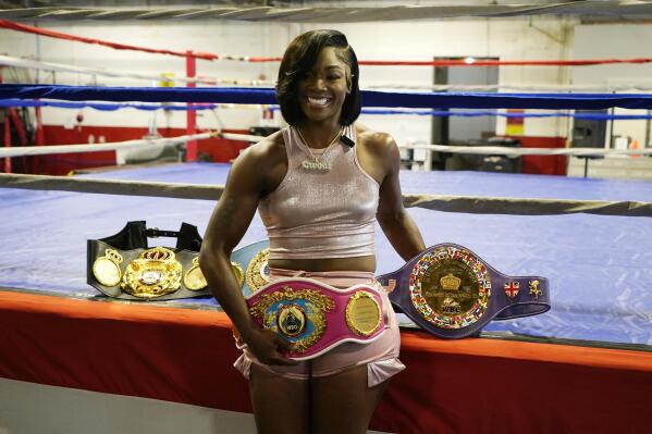 Claressa Shields poses with her prize belts after an interview, Tuesday, May 30, 2023, in Detroit. Shields is perhaps in the prime of her career, establishing a big enough name as a two-time Olympic gold medalist and world champion in three weight classes to headline the first boxing card in the six-year history of Little Caesars Arena. The undisputed middleweight champion faces top-ranked contender Maricela Cornejo on Saturday. (AP Photo/Carlos Osorio)