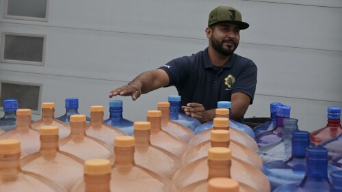 A man delivers bottled water to residences in the Santa Fe section of Tijuana where water shutoffs are common, on Friday, May 12, 2023. Among the last cities downstream to receive water from the shrinking Colorado River, Tijuana is staring down a water crisis. (AP Photo/Carlos A. Moreno)