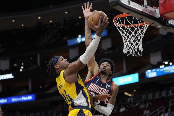 Indiana Pacers' Buddy Hield goes up for a shot as Houston Rockets' Christian Wood defends during the first half of an NBA basketball game Friday, March 18, 2022, in Houston. (AP Photo/David J. Phillip)