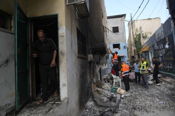 Palestinians municipality workers check a damaged house following an Israeli military operation in the West Bank refugee camp of Al-Faraa, Thursday, Aug. 29, 2024. (AP Photo/Nasser Nasser)