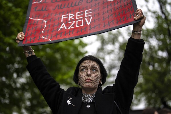 A woman holds a "Free Azov" sign during a rally aiming to raise awareness on the fate of Ukrainian prisoners of war in Kyiv, Ukraine, Sunday, April 21, 2024. The U.S. House of Representatives swiftly approved $95 billion in foreign aid for Ukraine, Israel and other U.S. allies in a rare Saturday session as Democrats and Republicans banded together after months of hard-right resistance over renewed American support for repelling Russia's invasion. (AP Photo/Francisco Seco)