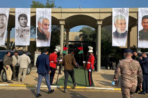 Mourners and security forces attend a ceremony to mark the second anniversary of the deaths of General Qassim Soleimani, third photo from left, and and Abu Mahdi al-Muhandis, second photo from right, in Baghdad's Green Zone, Iraq, Wednesday, Jan. 5, 2022. The 2020 U.S. drone strike at Baghdad's airport killed Soleimani, who was the head of Iran's elite Quds Force, and al-Muhandis, deputy commander of Iran-backed militias in Iraq known as the Popular Mobilization Forces. (AP Photo/Ali Abdul Hassan)