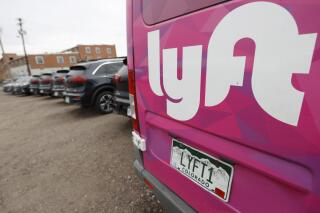 FILE - A Lyft ride-hailing vehicle is parked near Empower Field at Mile High in Denver on April 30, 2020. (AP Photo/David Zalubowski, File)