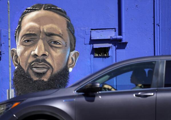 A motorist drives past a street mural of the late rapper Nipsey Hussle, Thursday, June 30, 2022, in downtown Los Angeles. The many murals of Hussle around Los Angeles speak to the late rapper's lasting legacy. (AP Photo/Chris Pizzello)