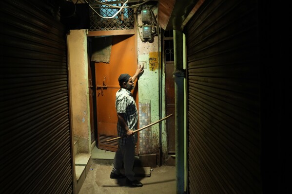 Dawn caller Umar Irshad, 53, knocks and presses the door bell a devout Muslim house to wake them up for pre dawn meal during the holy month of Ramadan in the old quarter of Delhi, India, Tuesday, March, 18, 2025. (AP Photo/Manish Swarup)