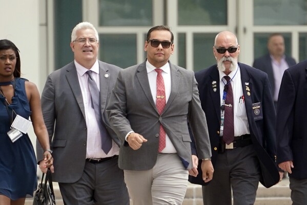 U.S. Rep. George Santos, center, with his attorney Joseph Murray, second from left, depart federal court with security and journalists in tow, Friday, June 30, 2023, in Central Islip, N.Y. Santos returned to court Friday for the first time since pleading not guilty last month to charges that he duped donors, stole from his campaign, collected fraudulent unemployment benefits and lied to Congress about being a millionaire. (AP Photo/John Minchillo)