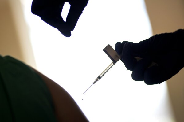 FILE - In this Tuesday, Dec. 15, 2020 file photo, a droplet falls from a syringe after a health care worker was injected with the Pfizer-BioNTech COVID-19 vaccine in Providence, R.I.  Some hospitals around the U.S. are facing complaints about favoritism and line-jumping after their board members and donors received COVID-19 vaccinations or offers for the prized inoculations. In Rhode Island, Attorney General Peter Neronha opened an inquiry after reports that two hospital systems offered their board members vaccinations.  (AP Photo/David Goldman, File)