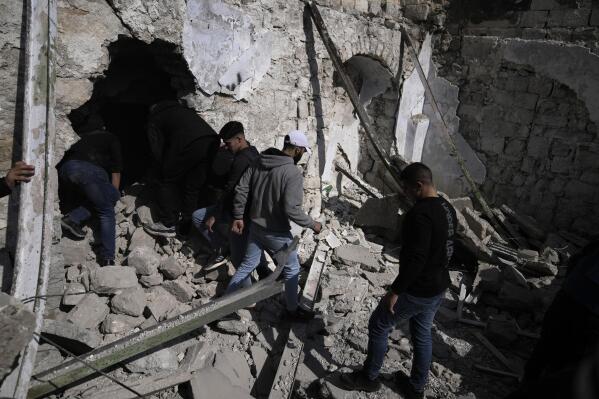 Palestinians inspect the ruins of a militant hideout destroyed during a raid by Israeli forces in the Old City of Nablus in the West Bank, Wednesday, Feb. 22, 2023. Israeli troops moved into the city, setting off fighting that killed several Palestinians, including a 72-year-old man, Palestinian health officials said. The Israeli military gave few details about its operation in the northern city, which is known as a militant stronghold, and the army frequently operates there. (AP Photo/Majdi Mohammed)
